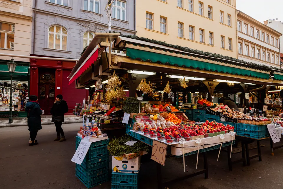 Étal de marché garni de produits frais tenu par un commerçant.