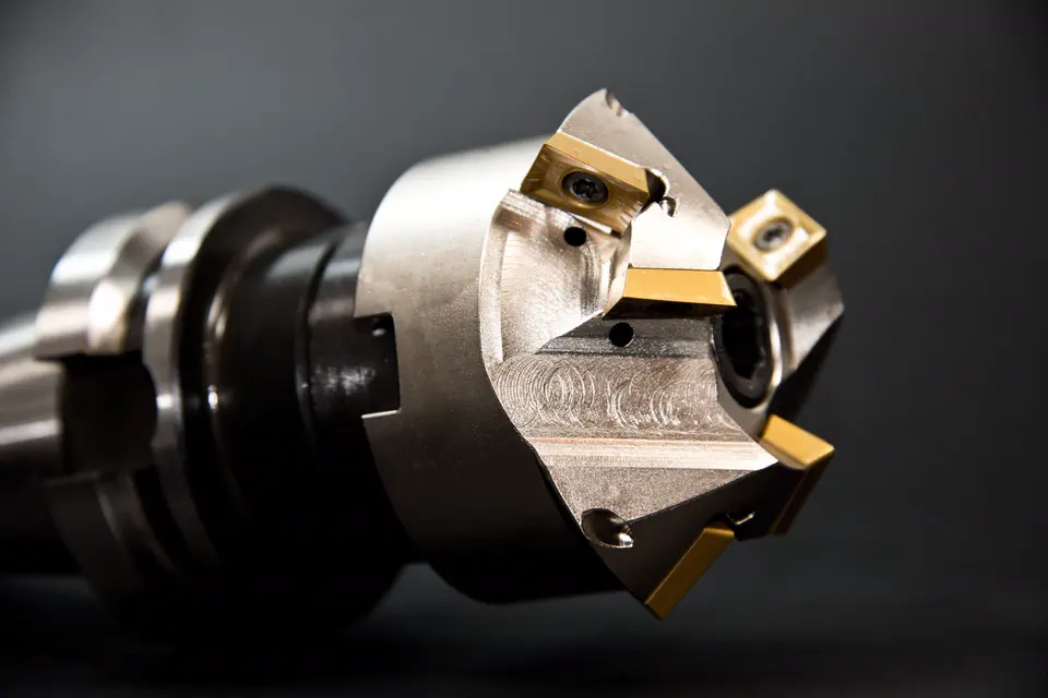 Pièces mécaniques usinées posées sur un établi d'atelier industriel.